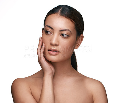 Buy stock photo Shot of a beautiful young woman touching her face while standing against a white background