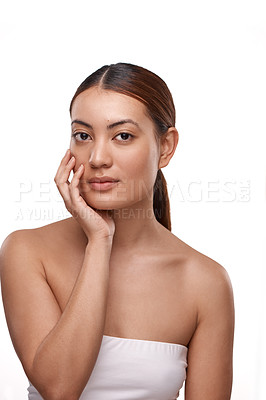 Buy stock photo Shot of a beautiful young woman touching her face while standing against a white background