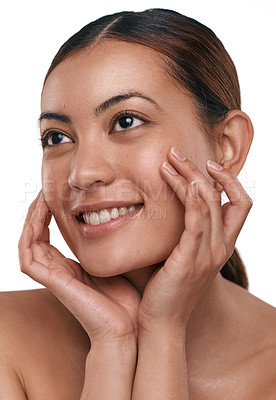 Buy stock photo Shot of a beautiful young woman touching her face while standing against a white background