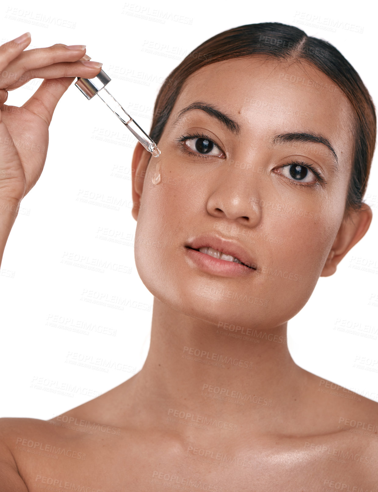 Buy stock photo Shot of a beautiful young woman posing with a serum dropper against her face