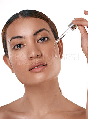 Buy stock photo Shot of a beautiful young woman posing with a serum dropper against her face