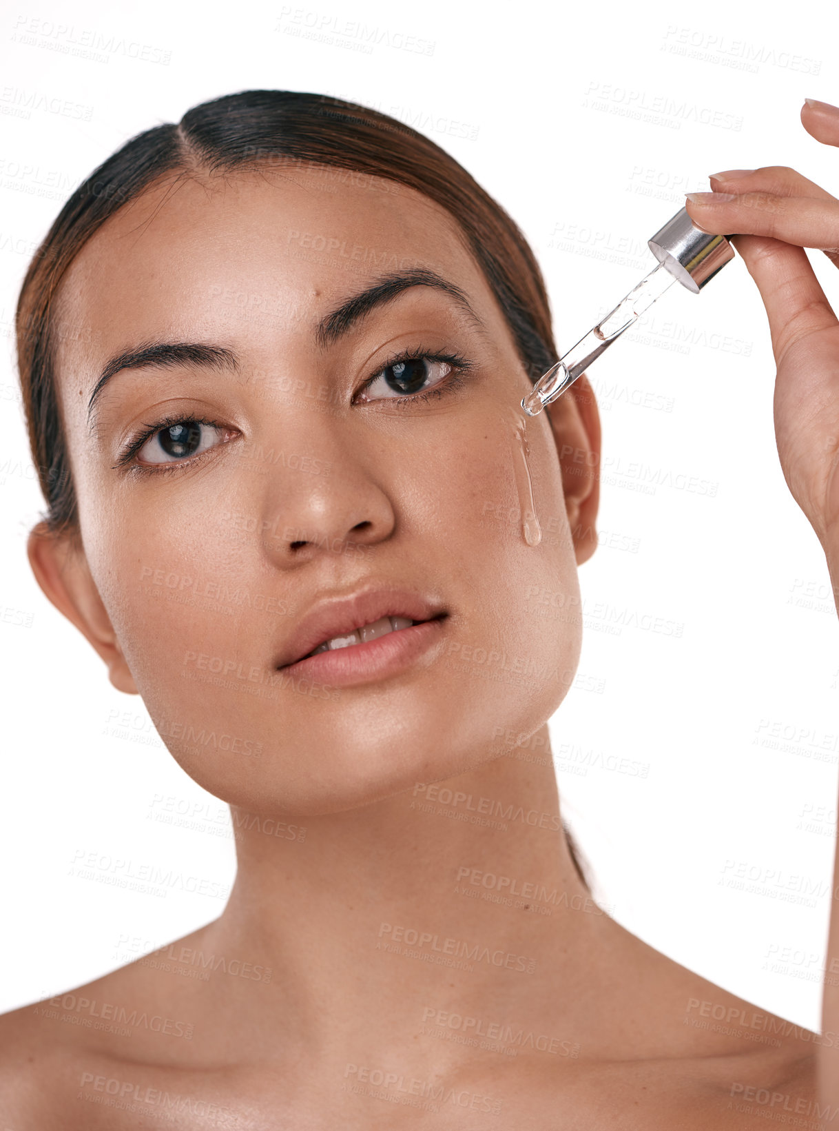 Buy stock photo Shot of a beautiful young woman posing with a serum dropper against her face