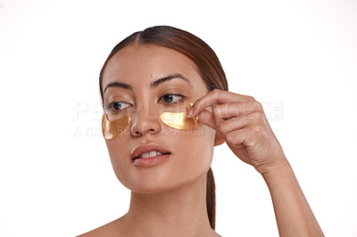 Buy stock photo Shot of a beautiful young woman wearing gold patches under her eyes