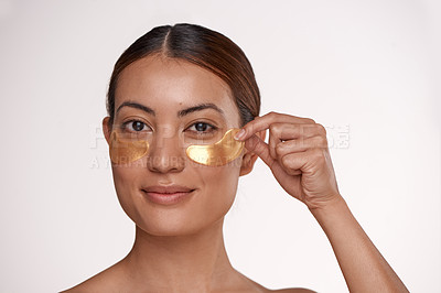 Buy stock photo Shot of a beautiful young woman wearing gold patches under her eyes