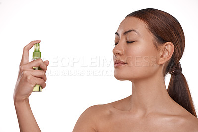 Buy stock photo Shot of a beautiful young woman holding up a bottle of face mist