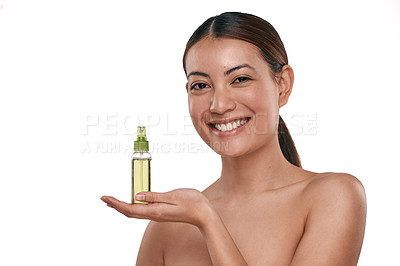 Buy stock photo Shot of a beautiful young woman holding up a bottle of face mist