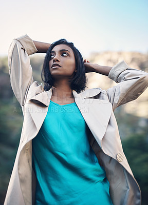 Buy stock photo Shot of a fashionable young woman posing against a nature background