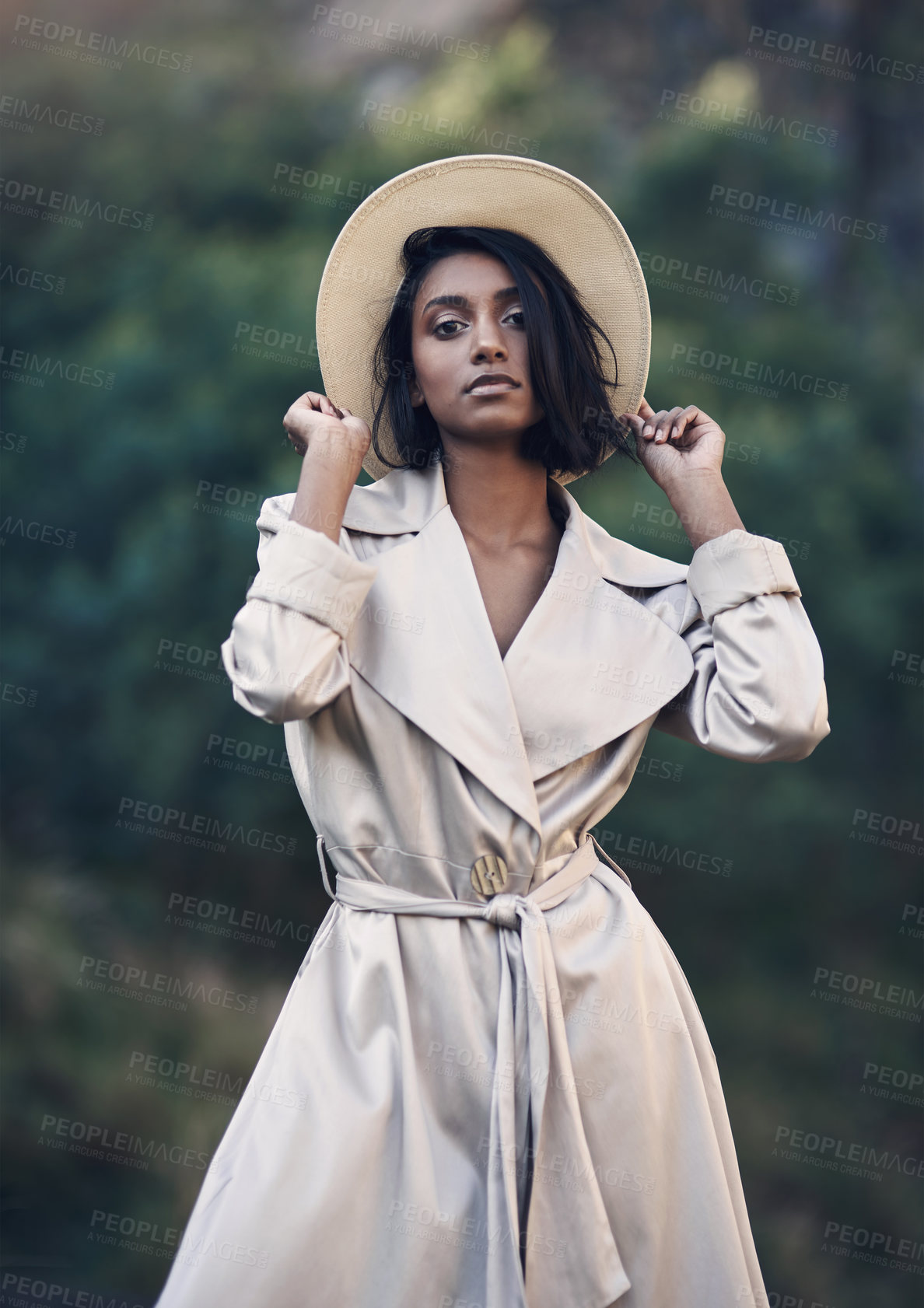 Buy stock photo Shot of a fashionable young woman posing against a nature background