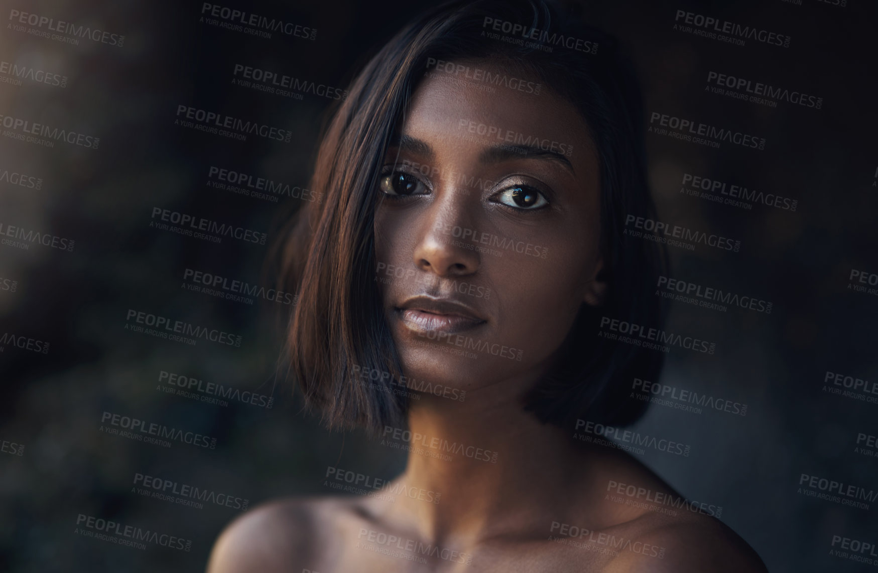 Buy stock photo Cropped shot of a beautiful young woman posing against a dark background