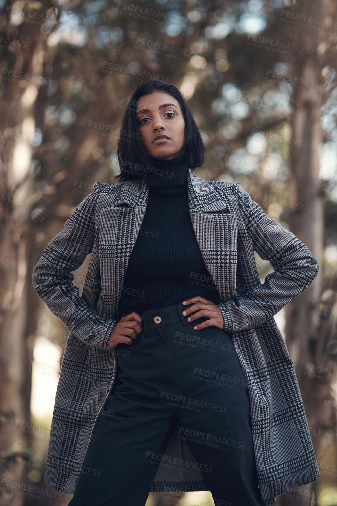 Buy stock photo Shot of a fashionable young woman posing against a nature background