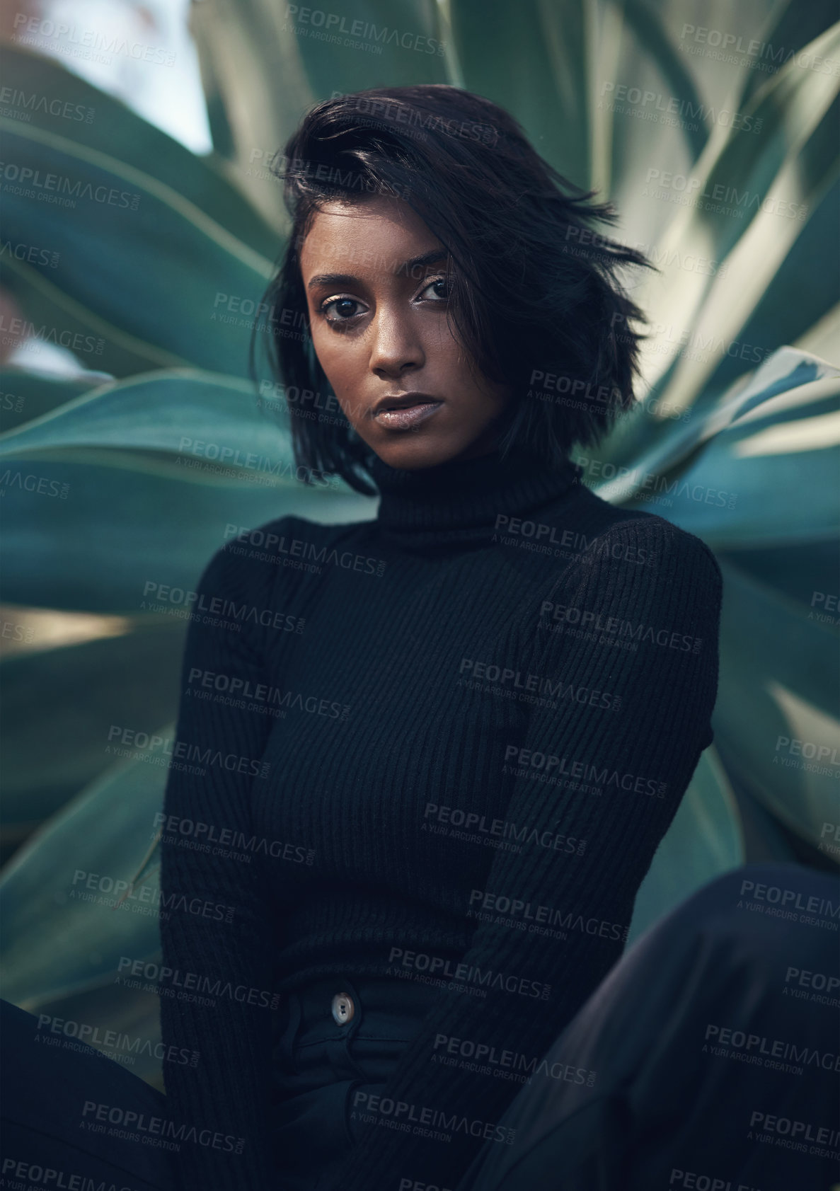 Buy stock photo Shot of a fashionable young woman posing against a nature background