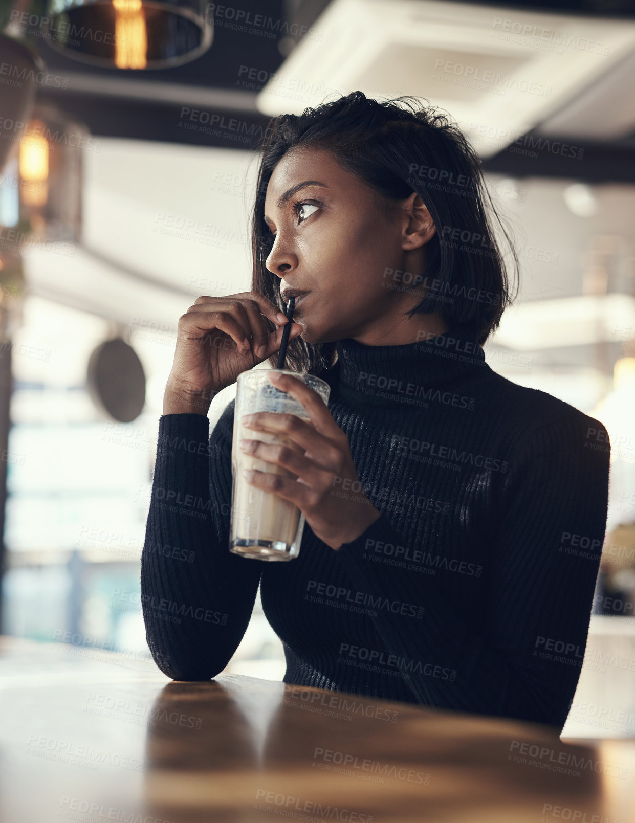 Buy stock photo Shot of a beautiful young woman drinking a iced coffee in a cafe