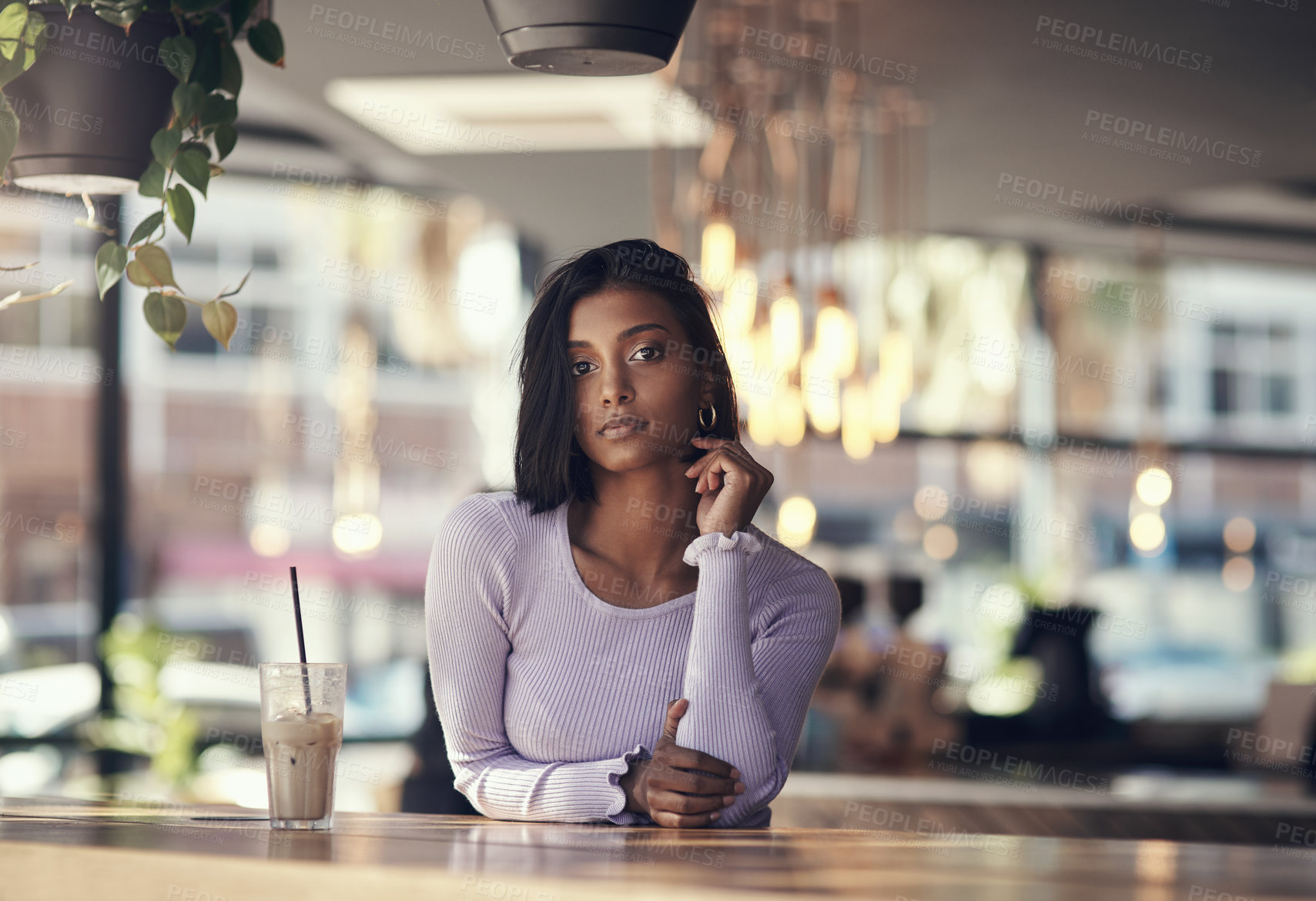 Buy stock photo Shot of a beautiful young woman drinking a iced coffee in a cafe