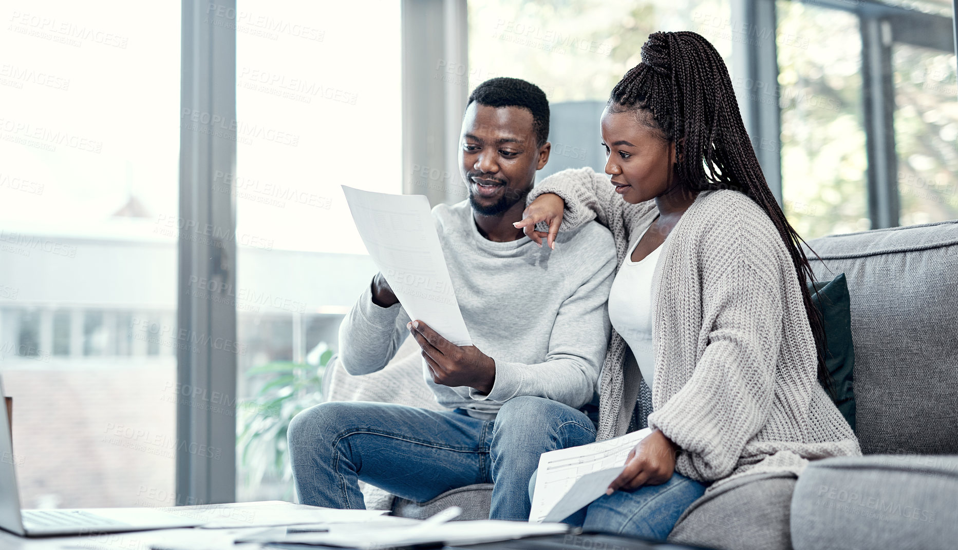 Buy stock photo Shot of a young couple going through paperwork at home