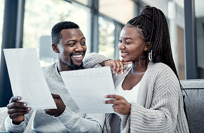 Buy stock photo Shot of a young couple going through paperwork at home