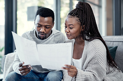 Buy stock photo Married couple planning their finance and budget bills or papers together at home. Serious husband and young wife looking at household financial report information and insurance money plan