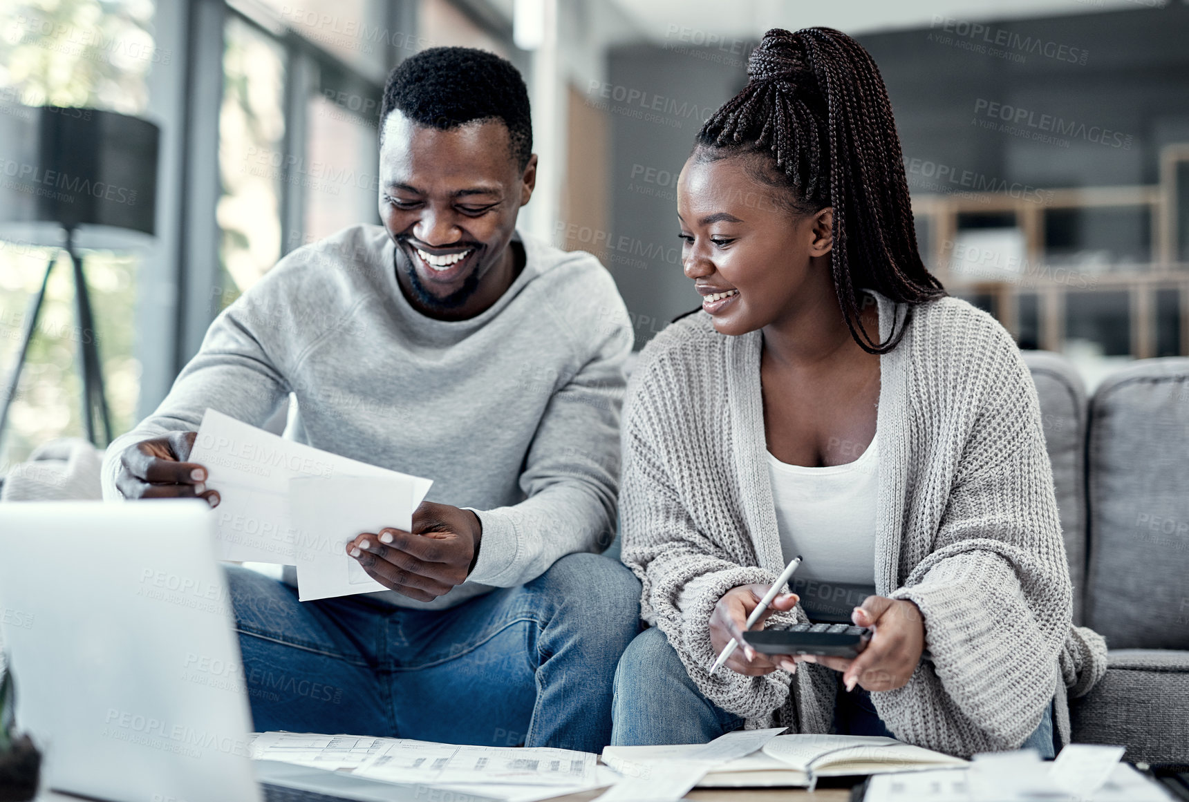 Buy stock photo Shot of a young couple going through paperwork at home