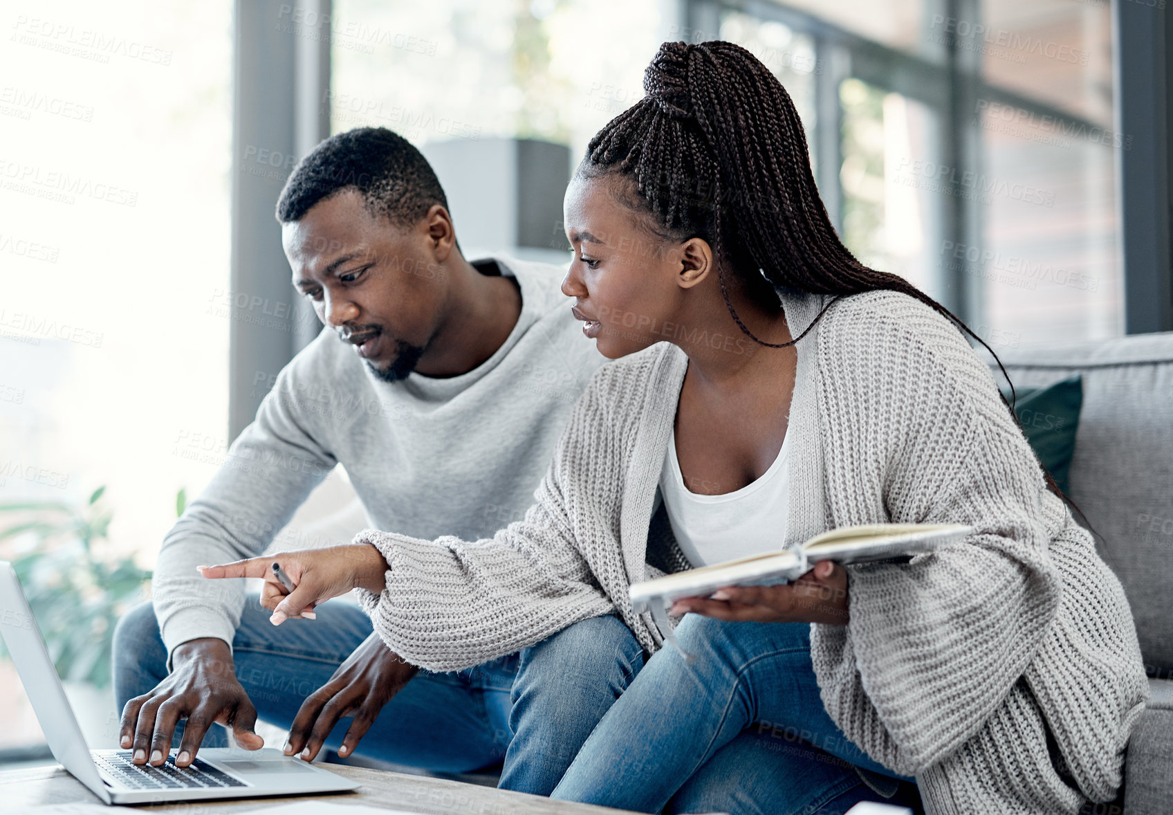 Buy stock photo Shot of a young couple working on their finances at home