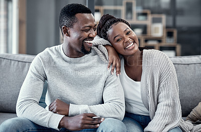 Buy stock photo Happy, in love, and carefree couple relaxing, smiling and laughing together at home portrait while enjoying their weekend spent indoors. Young African wife and loving husband bonding on their couch