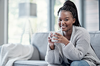 Buy stock photo Shot of a young woman having a relaxing coffee break on the sofa at home