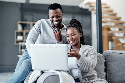 Buy stock photo Shot of a young couple using a laptop together on the sofa at home