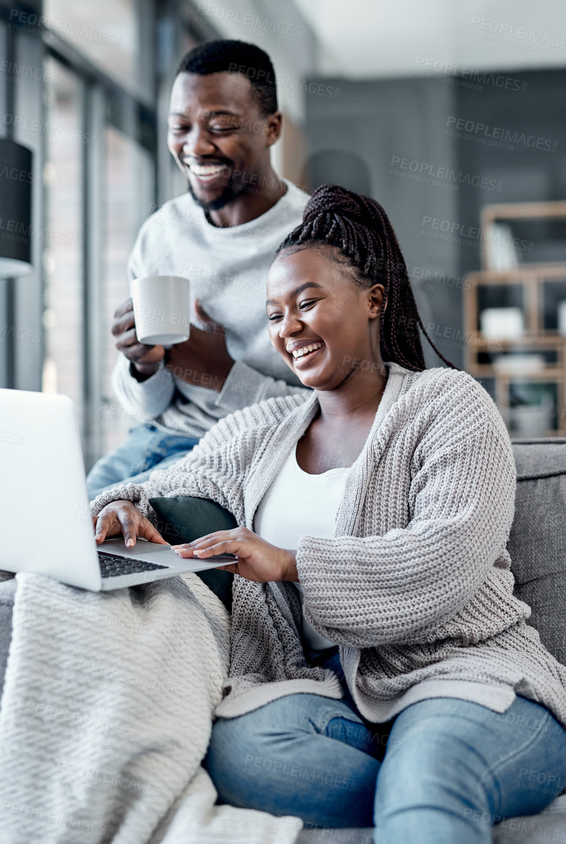 Buy stock photo Shot of a young couple using a laptop together on the sofa at home