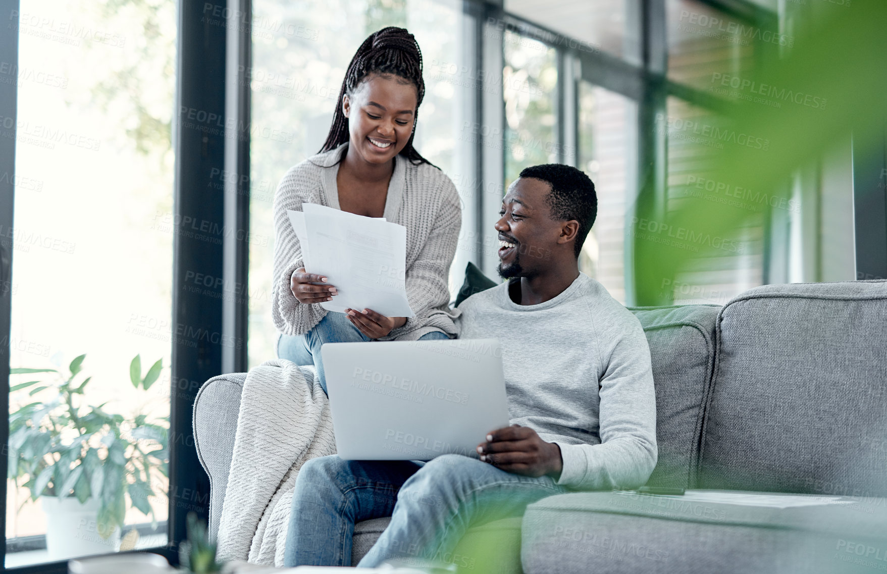 Buy stock photo Shot of a young couple going through paperwork at home