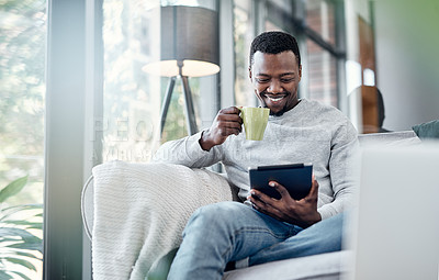 Buy stock photo Relax, coffee and tablet with an african man on a sofa, sitting in the living room of his home to browse social media. Smile, technology or internet with a happy male person relaxing alone in a house