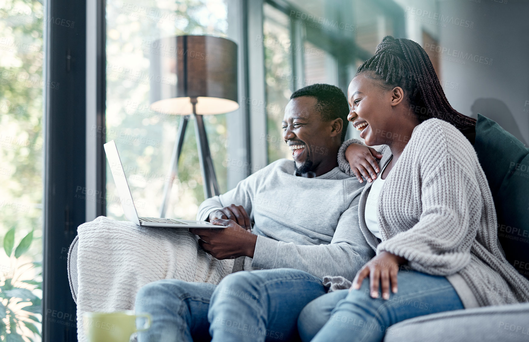 Buy stock photo Shot of a young couple using a laptop together on the sofa at home