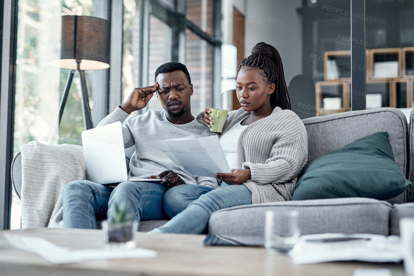 Buy stock photo Shot of a young couple going through paperwork at home