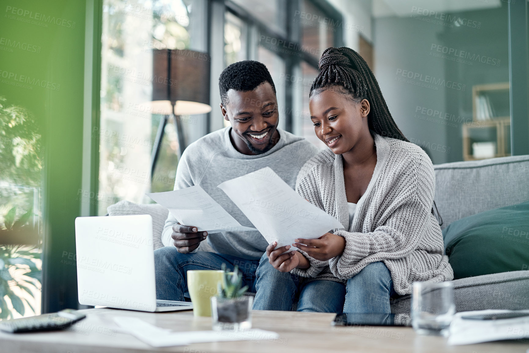 Buy stock photo Shot of a young couple going through paperwork at home