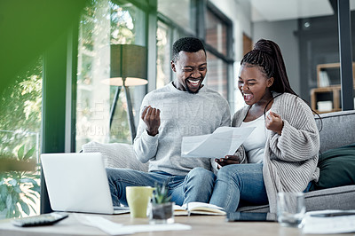 Buy stock photo Shot of a young couple celebrating while going through paperwork at home