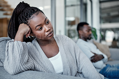 Buy stock photo Shot of a young couple ignoring each other after having an argument on the sofa at home