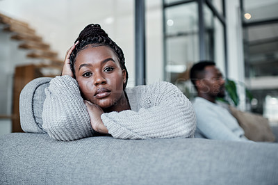 Buy stock photo Shot of a young couple ignoring each other after having an argument on the sofa at home