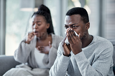 Buy stock photo Flu, cold or sick couple with covid coughing, sneezing and blowing their nose with a tissue while in isolation together at home in winter. Young husband and wife with a bad seasonal fever illness