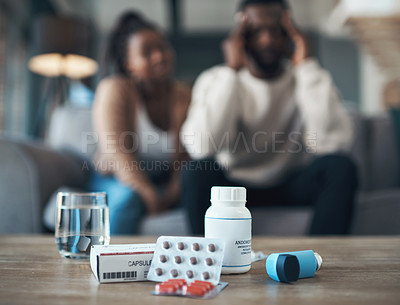 Buy stock photo Cropped shot of an unrecognizable couple sitting together at home and feeling sick while taking their medication