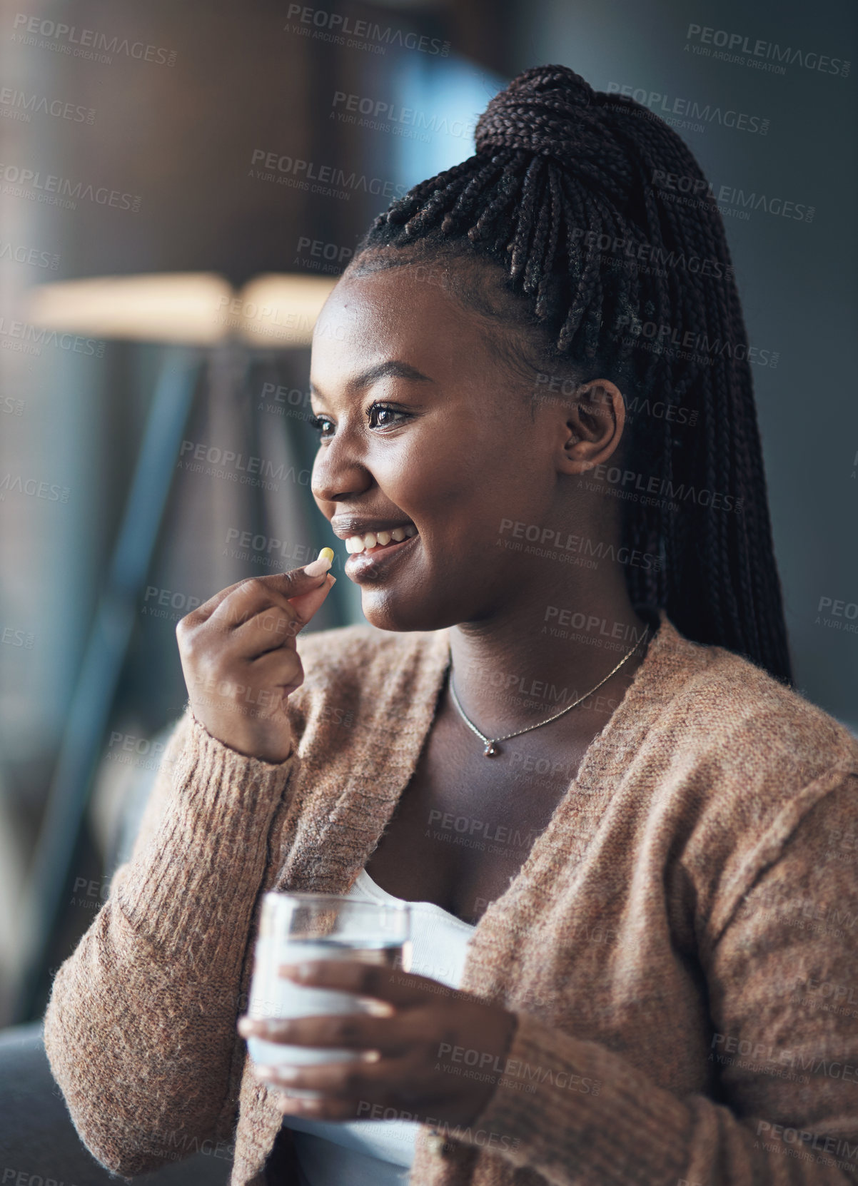 Buy stock photo Happy, black woman and pill with water in home for supplements, immune system or medication. Liquid glass, person and smile with capsule in house for magnesium tablet, health management and omega 3