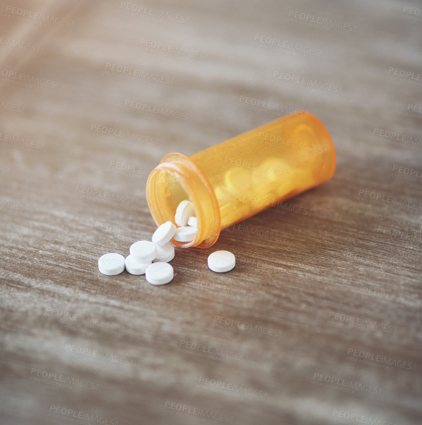 Buy stock photo Shot of a bottle of pills laying open on a table in a living room during the day