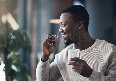 Buy stock photo Black man, pill or medicine and a glass of water in a house for health and wellness with a smile. Happy male person drinking pills, supplements or medication for healthcare, vitamins and energy