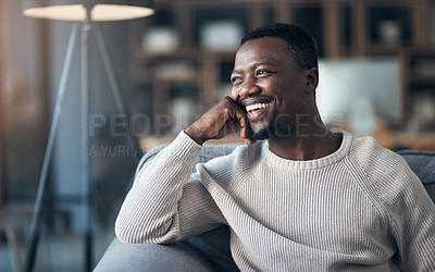 Buy stock photo Cropped shot of a handsome young man sitting alone and relaxing in his living room during the day
