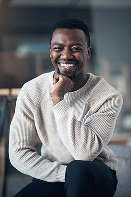 Buy stock photo Cropped shot of a handsome young man sitting alone and relaxing in his living room during the day