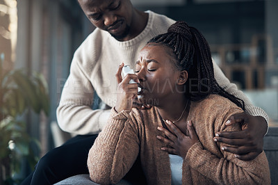 Buy stock photo Cropped shot of a handsome young man calming his girlfriend while she has an asthma attack at home