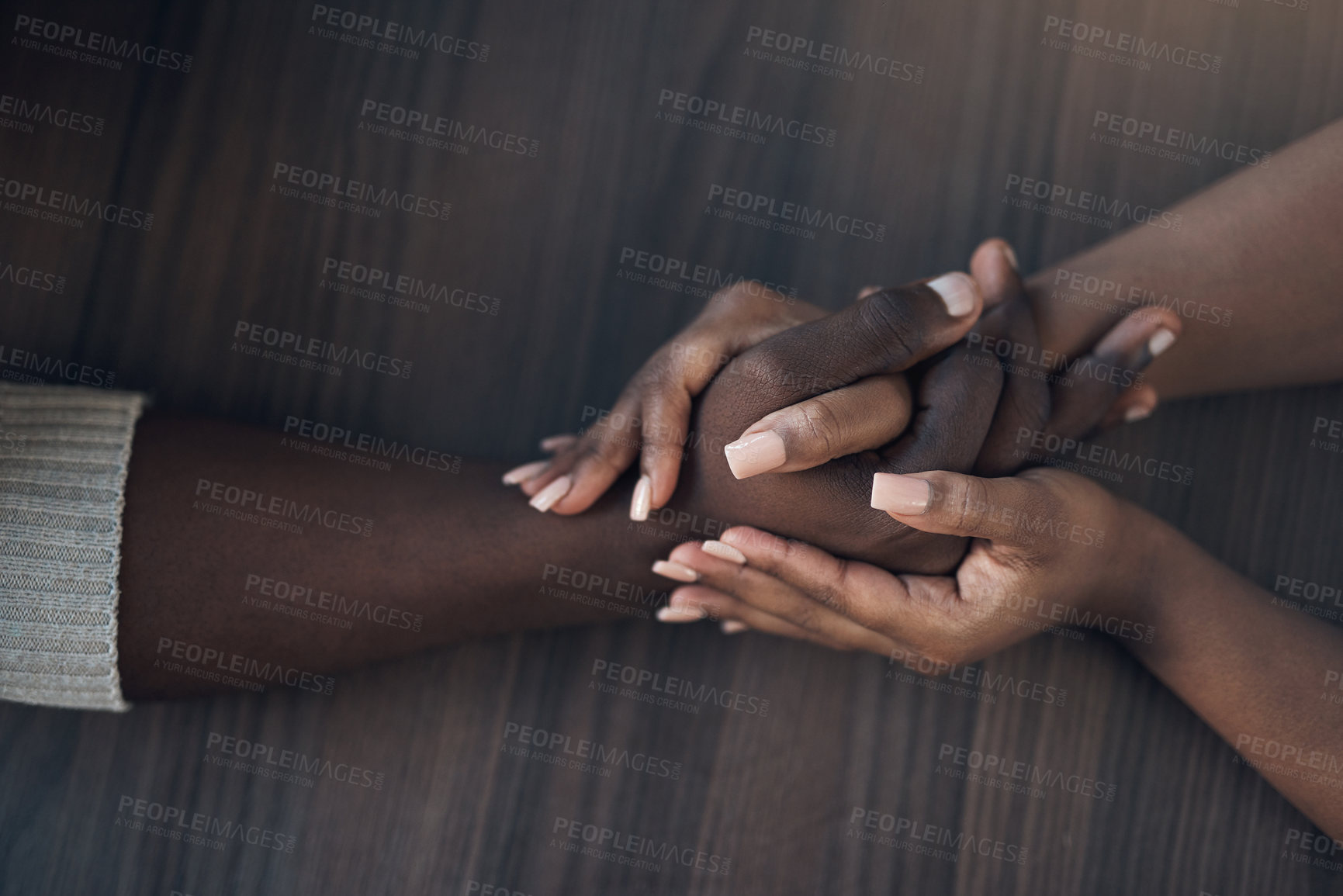 Buy stock photo Cropped shot of an unrecognizable couple holding hands while at home during the day