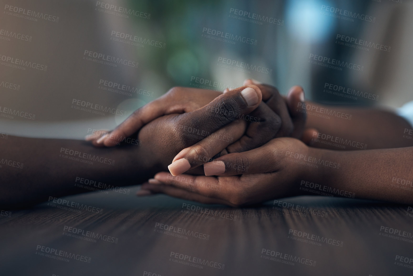 Buy stock photo Cropped shot of an unrecognizable couple holding hands while at home during the day