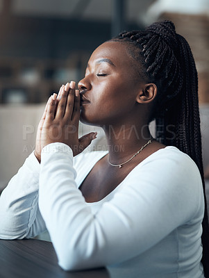 Buy stock photo Cropped shot of an attractive young woman kneeling alone and praying in her home