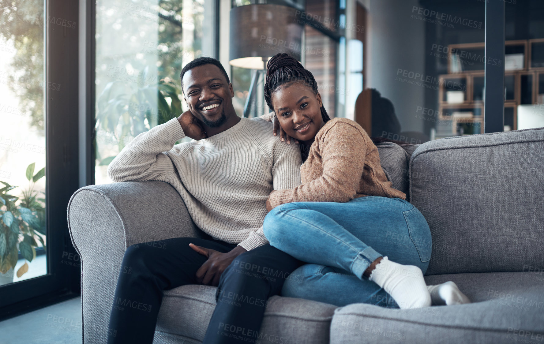 Buy stock photo Cropped shot of a happy young couple sitting together and bonding during their weekend at home