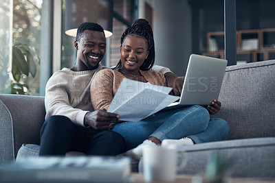 Buy stock photo Cropped shot of a young couple sitting on the sofa together and using a laptop while going through their finances