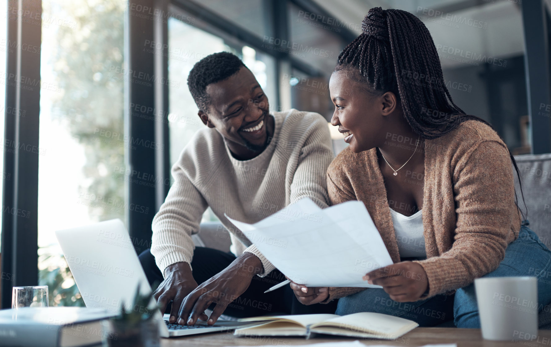 Buy stock photo Cropped shot of a young couple sitting on the sofa together and using a laptop while going through their finances