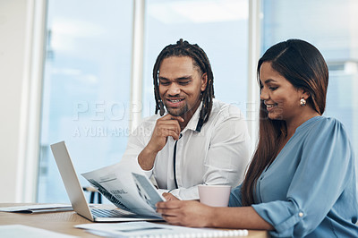 Buy stock photo Shot of two businesspeople going through paperwork together in an office