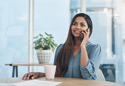 Buy stock photo Shot of a young businesswoman talking on a cellphone in an office